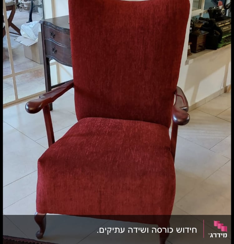 כורסה מרופדת בבד אדום עם ידיות עץ